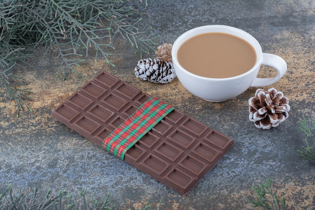 Een kopje koffie met dennenappels en chocolade. Hoge kwaliteit foto