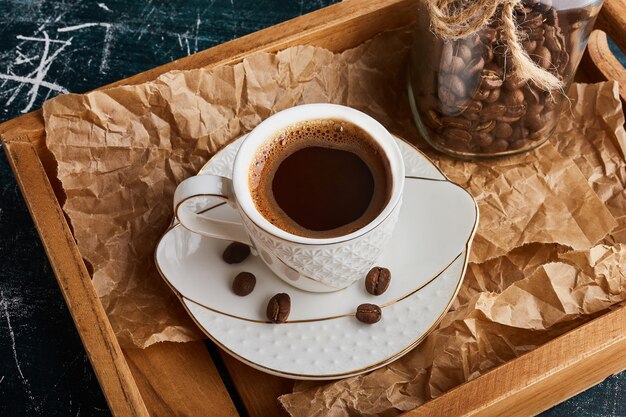 Een kopje koffie op een witte schotel.