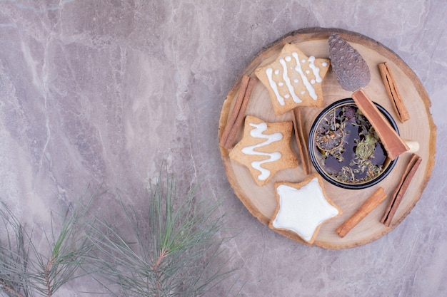 Een kopje kruidenthee met peperkoek op een houten bord