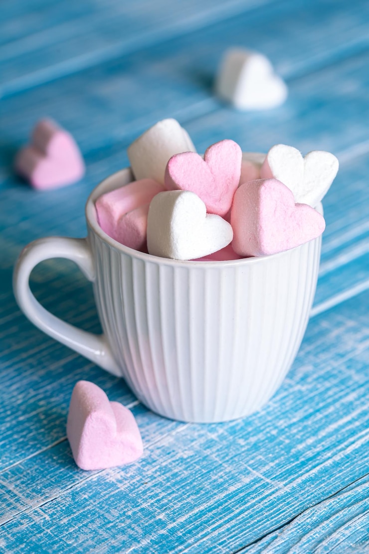 Gratis Foto een kopje met hartvormige marshmallows close-up op een blauwe houten achtergrond