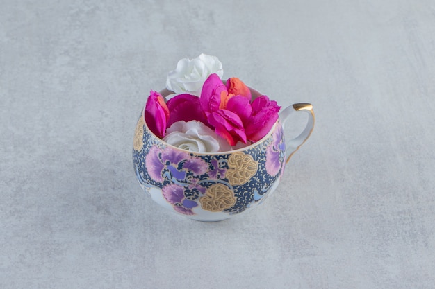 Gratis foto een kopje paarse en witte bloemen, op de witte tafel.