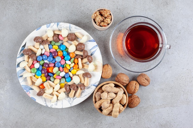 Een kopje thee naast assortiment van snoep en noten op marmeren achtergrond. Hoge kwaliteit foto