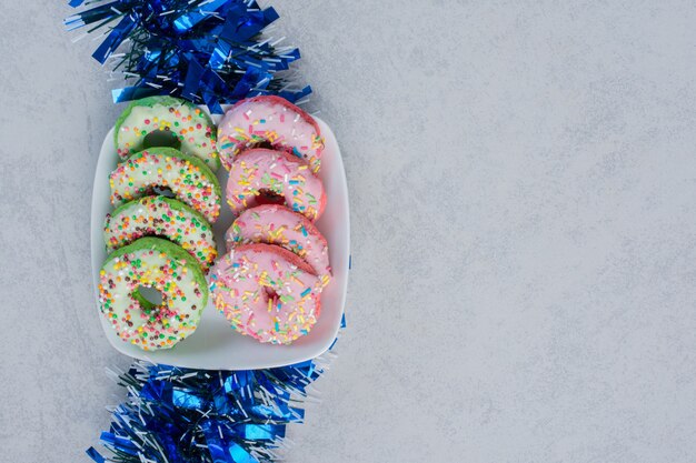 Een krans en een schaal met donuts op een marmeren oppervlak