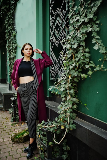 Een lange langbenige jonge, mooie en elegante modelvrouw bij claret coat