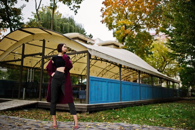 Een lange langbenige jonge, mooie en elegante modelvrouw bij claret coat