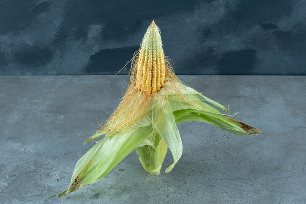 Een maïsplant bedekt met groene bladeren op de grond. Hoge kwaliteit foto