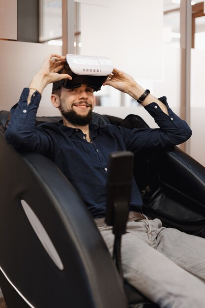 Een man in een massagestoel met VR-technologie