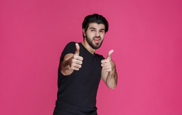 Een man in een zwart shirt voelt zich ergens positief over en geniet ervan