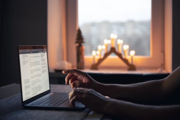 Gratis foto een man leest het nieuws terwijl hij 's nachts voor een laptopscherm zit