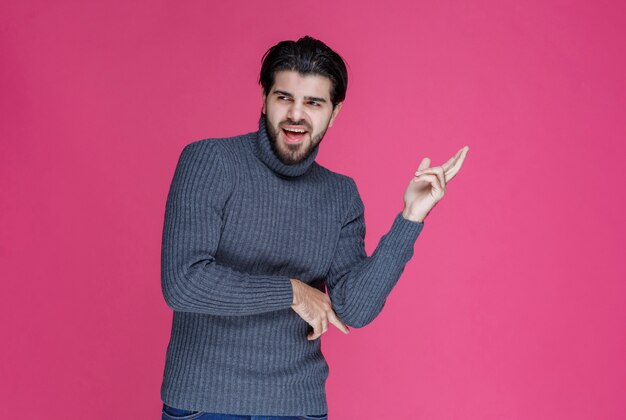 Een man met een zwarte baard ziet er krachtig en zelfverzekerd uit.