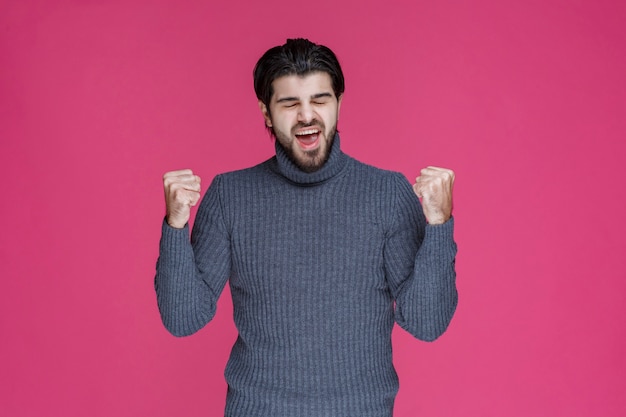 Een man met een zwarte baard ziet er krachtig en zelfverzekerd uit.