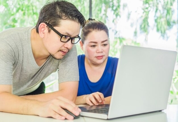 Een man traint een vrouw die met een computer werkt in een modern kantoor