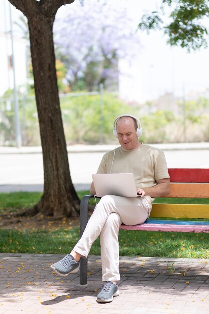 een man werkt op een laptop in het park