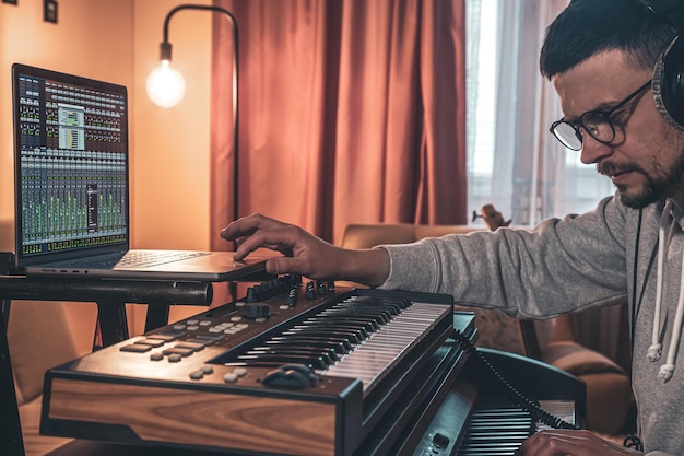 Een mannelijke muzikant speelt de muzikale toetsen in een koptelefoon