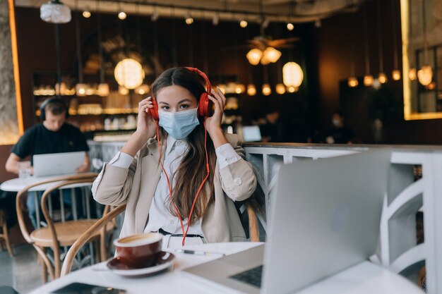 Een meisje dat in een coffeeshop zit met een uitbraak van het coronavirus