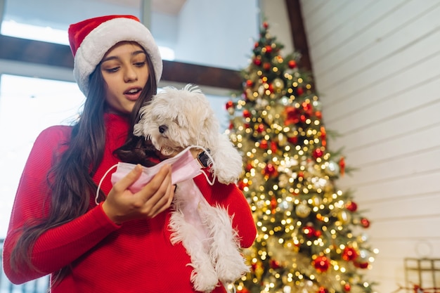 Een meisje houdt een kleine hond op haar handen op oudejaarsavond nieuwjaar met een vriend