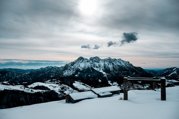 Een met sneeuw bedekte hut met een prachtig uitzicht op met sneeuw bedekte bergen