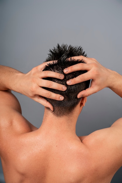 Een middelgrote man geeft zichzelf een scalp massage.