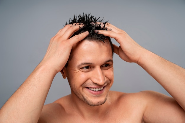 Een middelgrote man geeft zichzelf een scalp massage.