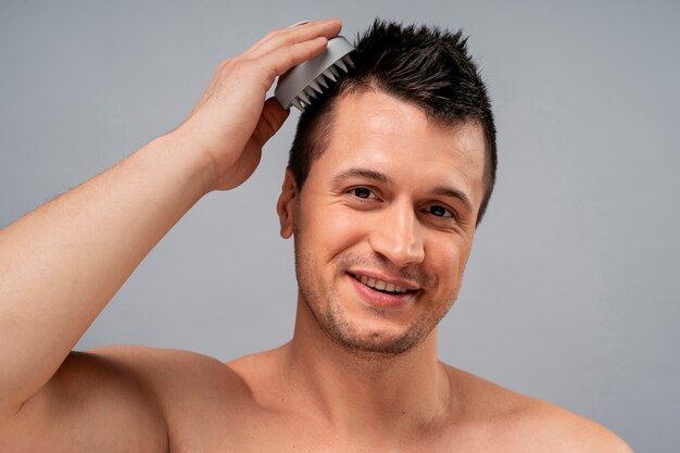 Een middelgrote man geeft zichzelf een scalp massage.