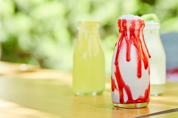 Een milkshake en twee limonades op houten tafel.