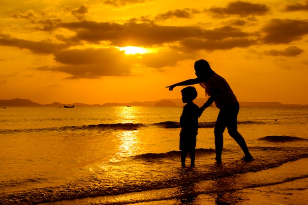 Een moeder en zoon in buiten bij zonsondergang met kopie ruimte