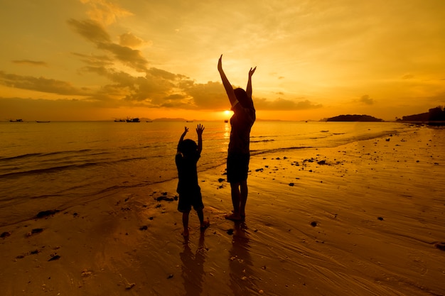Een moeder en zoon in buiten bij zonsondergang met kopie ruimte