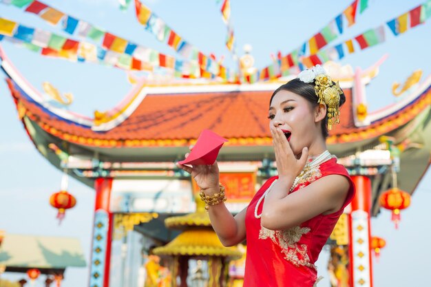 Een mooi Aziatisch meisje dat een rode kleding draagt
