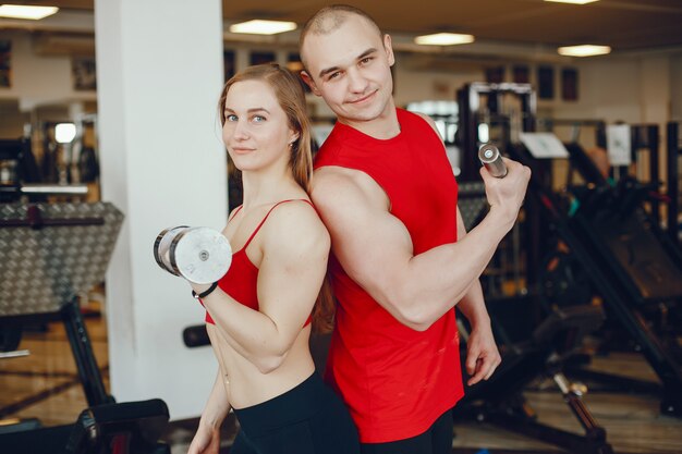 Een mooi en atletisch sportkledingmeisje dat in de gymnastiek met vriend opleidt