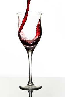 Een mooi glas serveren met een heerlijke rode wijn. witte achtergrond, glazen beker. elegantie, goede smaak, stijlconcept.