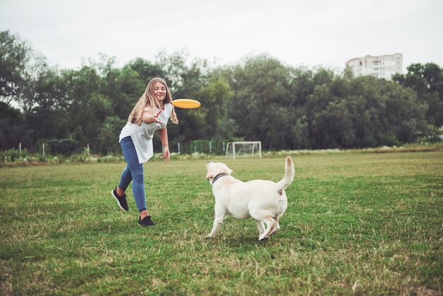 Een mooi meisje speelt met haar geliefde hond in het park.