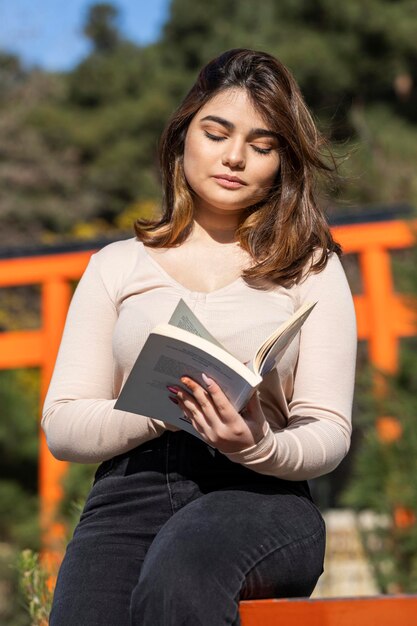 Een mooi meisjesleesboek in het park Foto van hoge kwaliteit