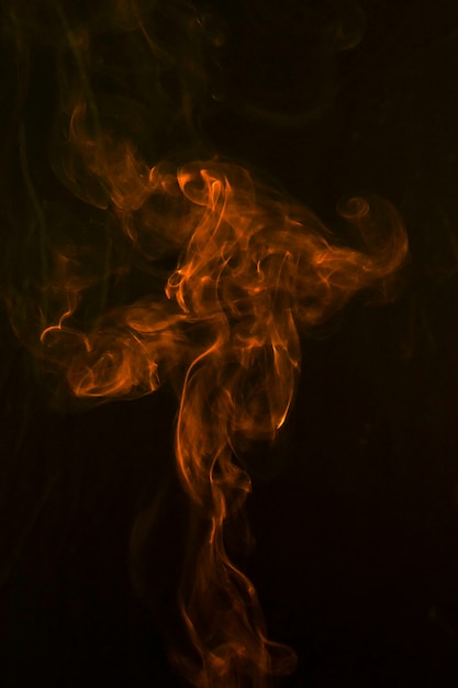 Een oranje abstracte rook buigt en zwaait op zwarte achtergrond