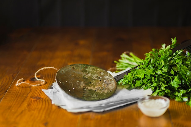 Een oude skimmer op papieren zakdoekje met koriander en knoflook dip kom over de houten tafel