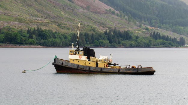 Een oude sleepboot afgemeerd aan een meer in Schotland, Verenigd Koninkrijk