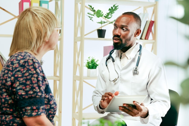 Gratis foto een oudere vrouw die een therapeut in de kliniek bezoekt voor consultatie en het controleren van haar gezondheid.