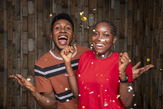 Een paar jonge Afrikaanse mannen en vrouwen vieren feest met rondzwevende confetti