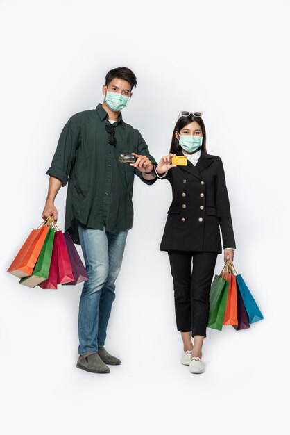 Een paar mannen en vrouwen droegen maskers en droegen veel papieren zakken om te winkelen