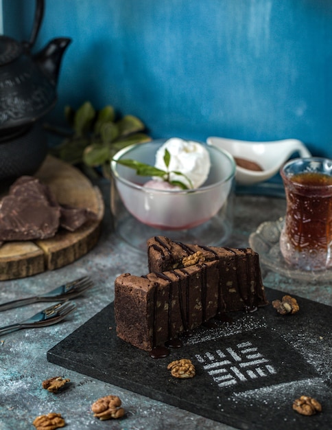 Een plak chocolade brownie cake met een glas thee