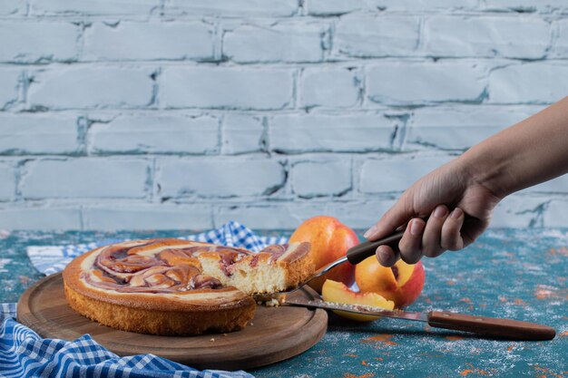 Een plakje aardbeientaart snijden op een houten bord.