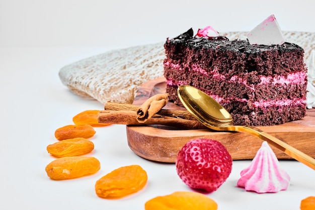Een plakje chocoladekaramelcake met aardbeiencrème.