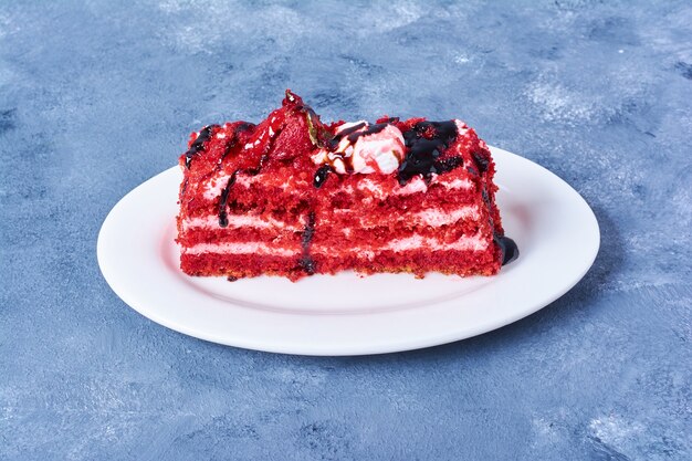 Een plakje rood fluwelen cake in een witte plaat
