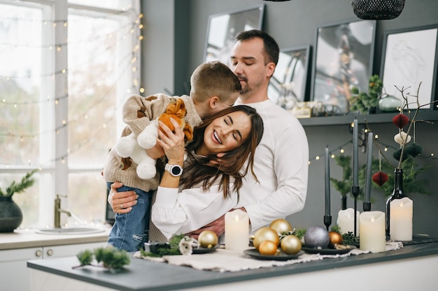 Een portret van een gelukkige familie in de keuken, versierd voor Kerstmis