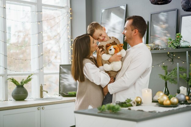 Een portret van een gelukkige familie in de keuken, versierd voor Kerstmis