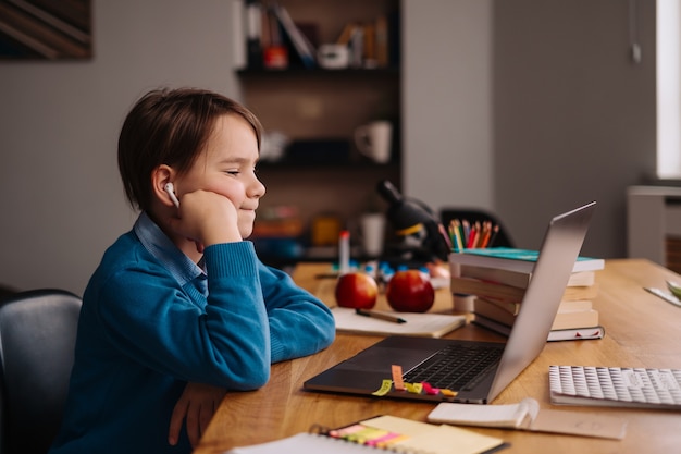 Een Preteen-jongen gebruikt een laptop om online lessen te geven
