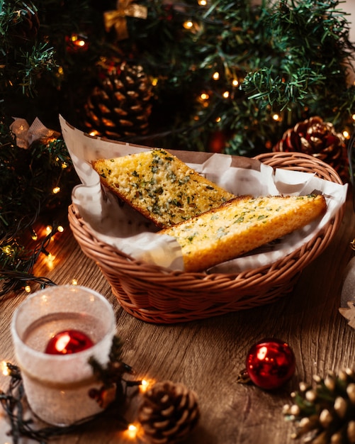 Een rieten mand met lookbrood gegarneerd met kruiden en kaas