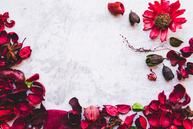 Een rode welriekend mengsel van gedroogde bloemen en kruidenriem tegen witte geweven achtergrond