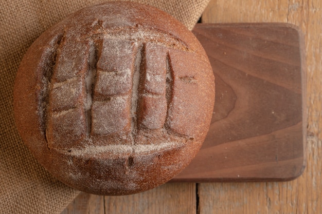 Een rond Frans roggebrood op een houten bord.