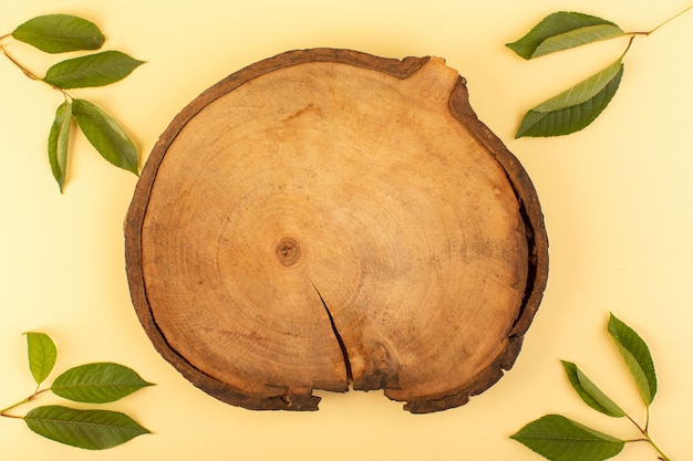 Gratis foto een rustieke houten bureau rustieke bovenaanzicht samen met groene bladeren gekleurde abrikoos