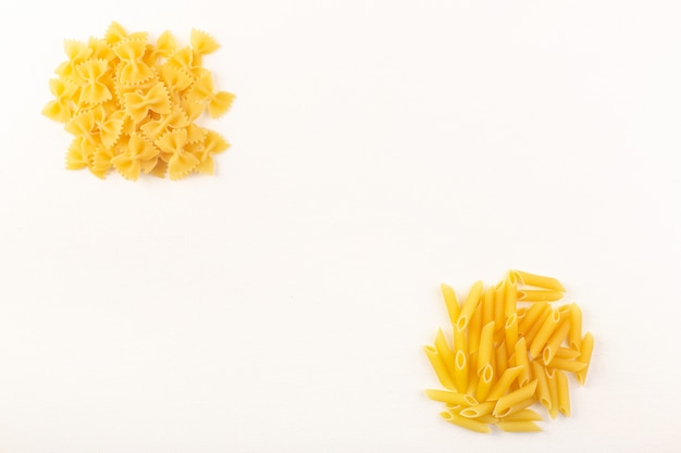 Een ruwe gele de deegwareninzameling van vooraanzicht italiaanse droge deegwaren voerde op de witte achtergrond voedselmaaltijd italiaans